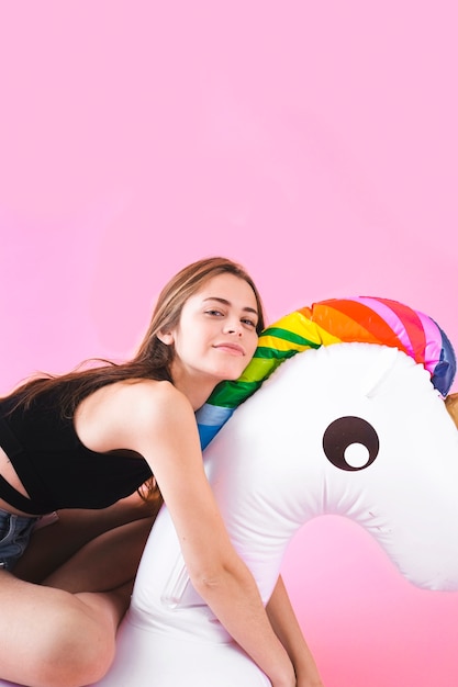 Foto gratuita concepto de moda de verano con mujer joven en unicornio inflable