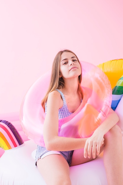 Concepto de moda de verano con mujer joven en unicornio inflable