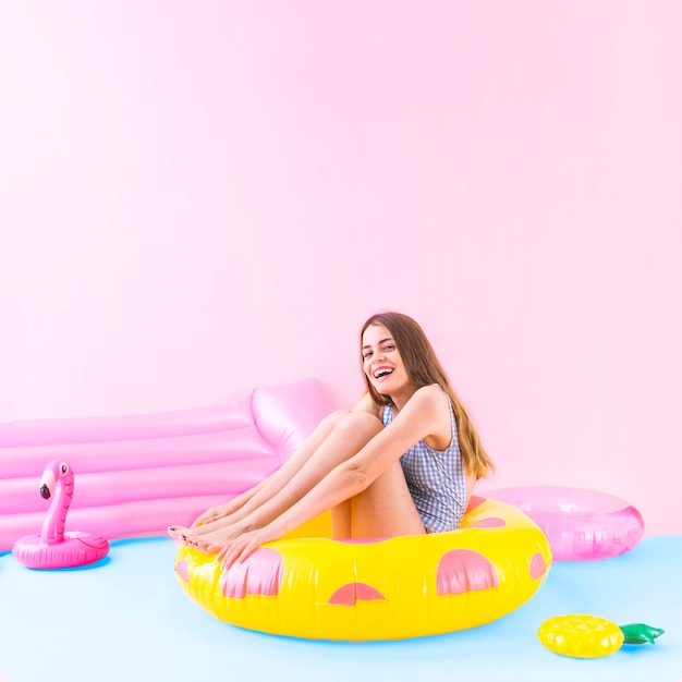 Foto gratuita concepto de moda de verano con mujer sentada en anillo inflable