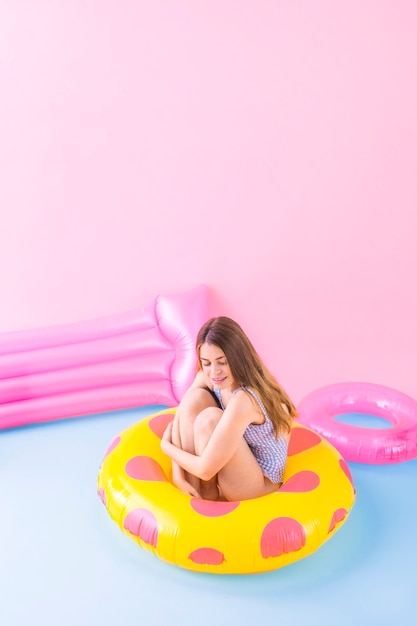 Concepto de moda de verano con mujer sentada en anillo inflable