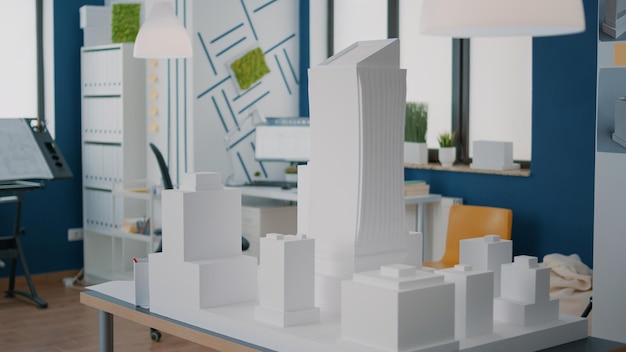 Concepto de modelo de construcción y diseño de la construcción en la mesa en el lugar de trabajo vacío. Maqueta y plano de propiedad urbana utilizada para desarrollo inmobiliario. Estructura de planos arquitectónicos.