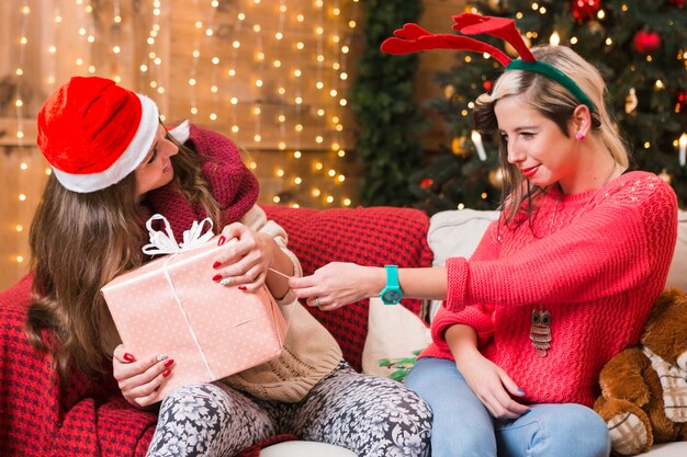 Concepto de navidad con chicas en sofá con regalos