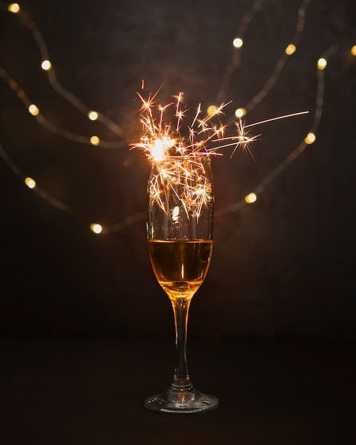 Concepto de Navidad con copa de champán y fuegos artificiales.