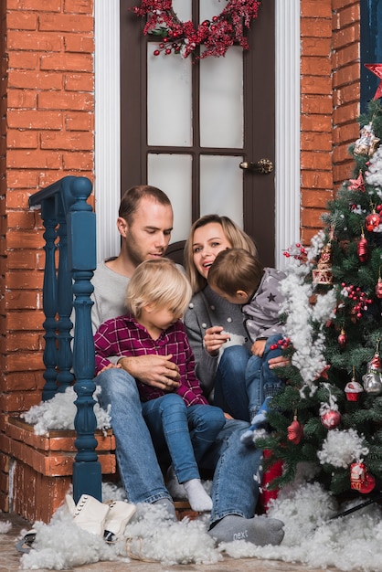 Concepto de navidad con familia sentada fuera