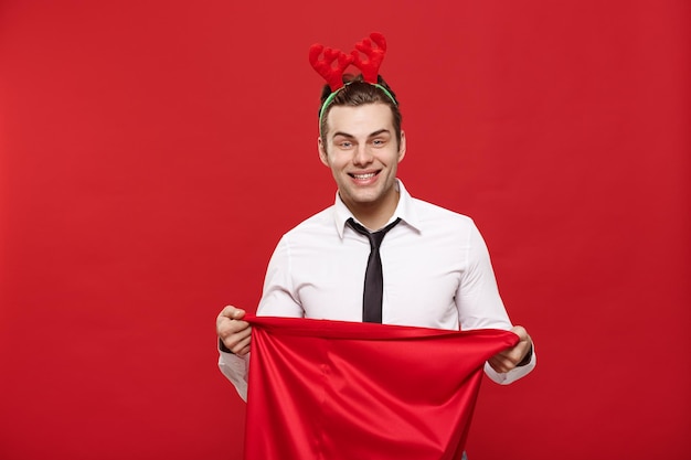 Concepto de Navidad Guapo hombre de negocios celebrar feliz Navidad y feliz año nuevo usar vincha de reno sosteniendo el bolso rojo de Santa