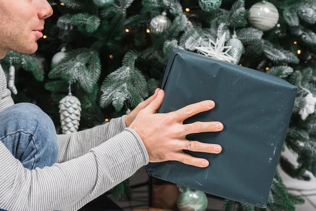 Foto gratuita concepto de navidad con hombre sujetando regalo