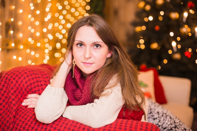 Concepto de navidad con mujer joven en sofá