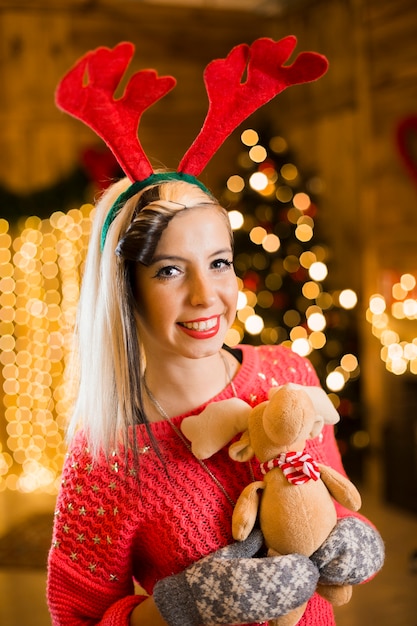 Foto gratuita concepto de navidad con mujer sonriente sujetando juguete