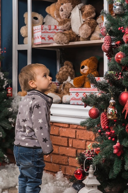 Concepto de navidad con niño mirando a árbol de navidad