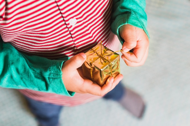 Foto gratuita concepto de navidad con niño sujetando caja de regalo pequeño