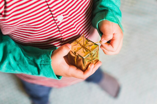 Concepto de navidad con niño sujetando caja de regalo pequeño