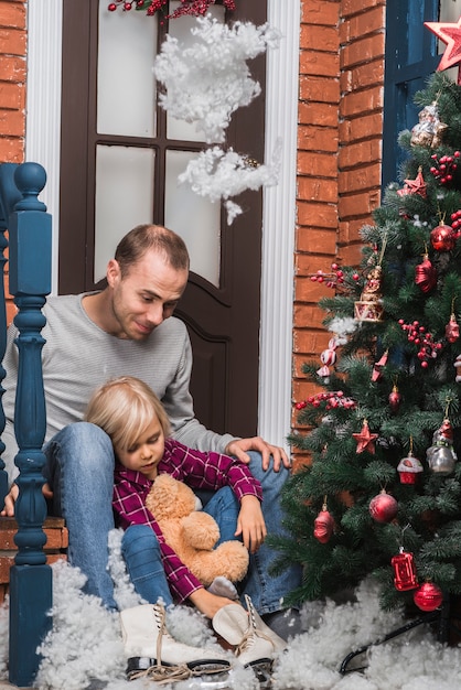 Concepto de navidad con padre e hija sentados