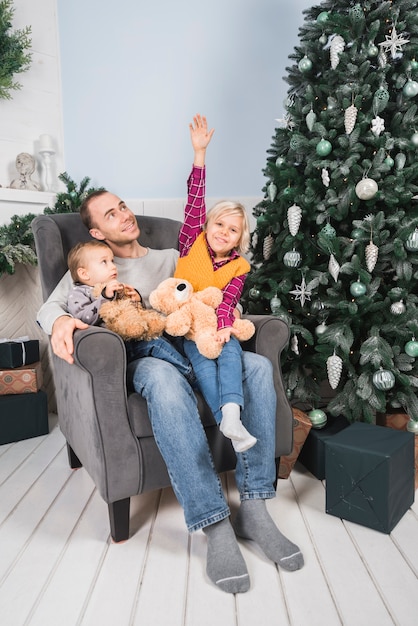 Foto gratuita concepto de navidad con padre sujetando niños