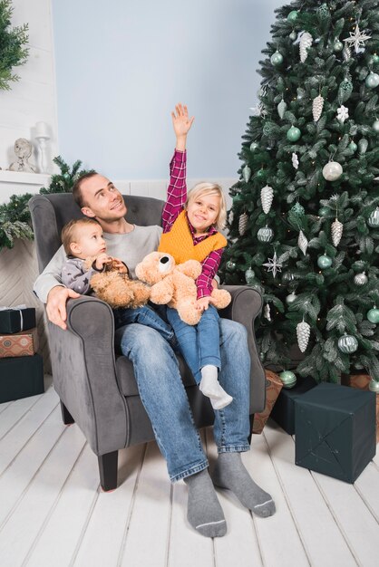 Concepto de navidad con padre sujetando niños