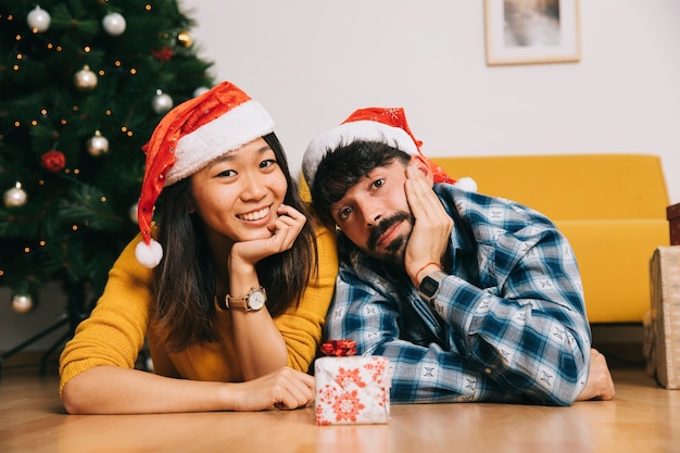 Concepto de navidad con pareja enfrente de caja de regalo pequeña