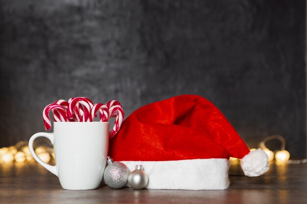 Concepto de Navidad con sombrero de santa y taza con dulces
