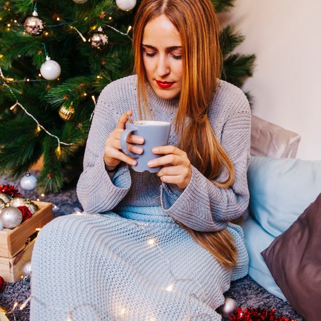 Foto gratuita concepto de navidad y té con mujer mirando a taza