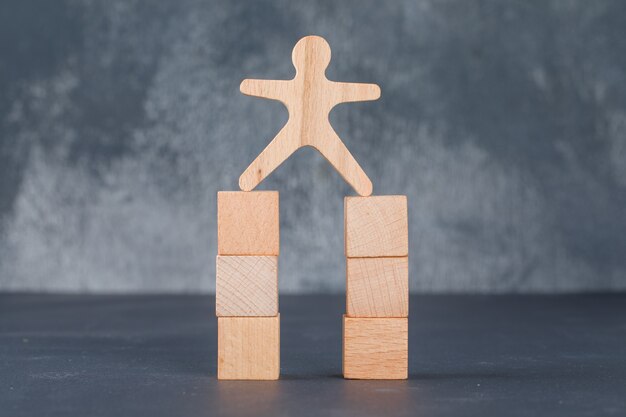 Concepto de negocio con bloques de madera con figura humana de madera.