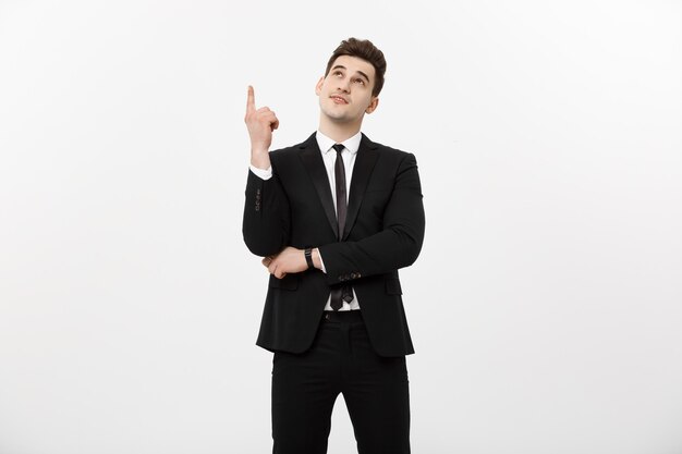Concepto de negocio: empresario guapo con un dedo apuntando hacia arriba aislado sobre fondo blanco.