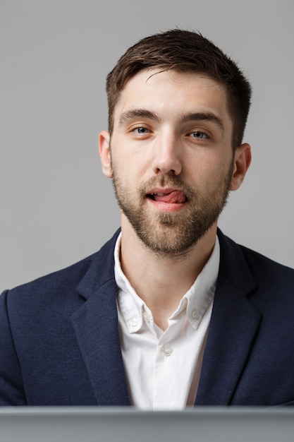 Concepto de negocio - retrato apuesto hombre de negocios guapo feliz en traje sonriendo y localización en la oficina de trabajo. Fondo blanco.