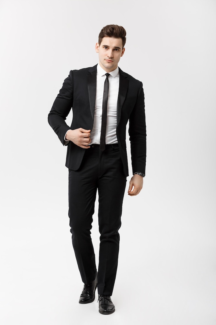 Foto gratuito concepto de negocio: retrato de cuerpo entero de un hombre de negocios elegante en traje elegante caminando sobre fondo blanco.