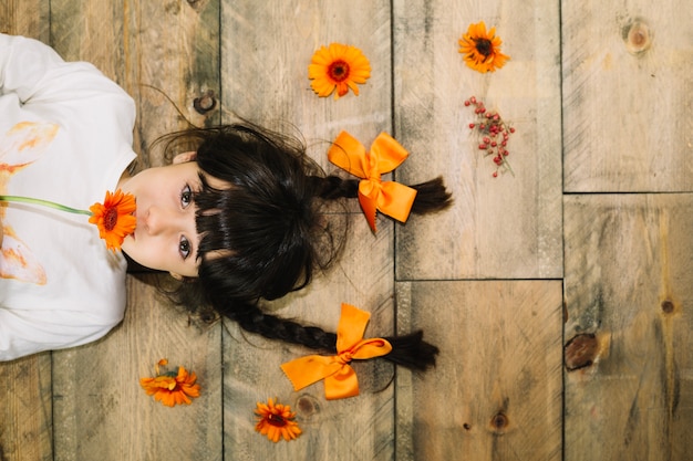 Foto gratuita concepto de otoño con niña con flor en la boca