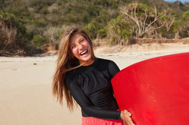 Concepto de paddleboarding y wakesurf. Alegre mujer de pelo largo aficionada al surf