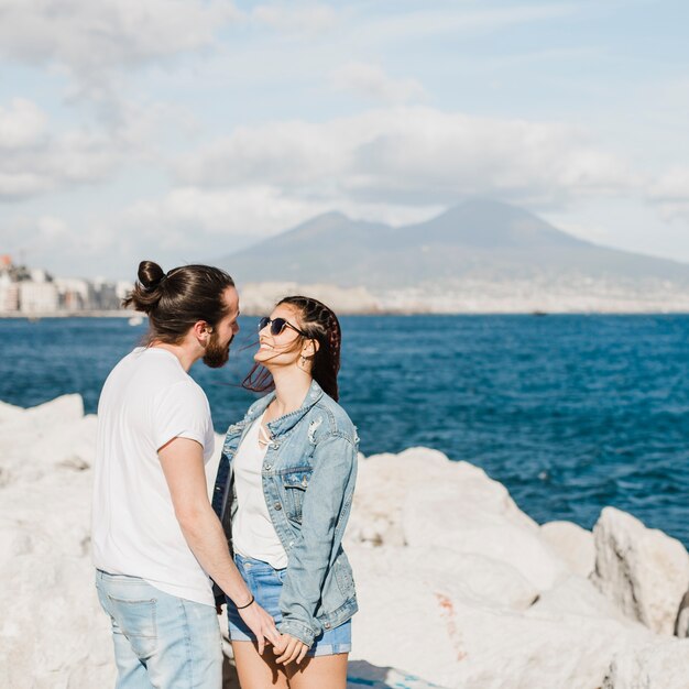 Concepto de pareja y verano en rocas por el mar