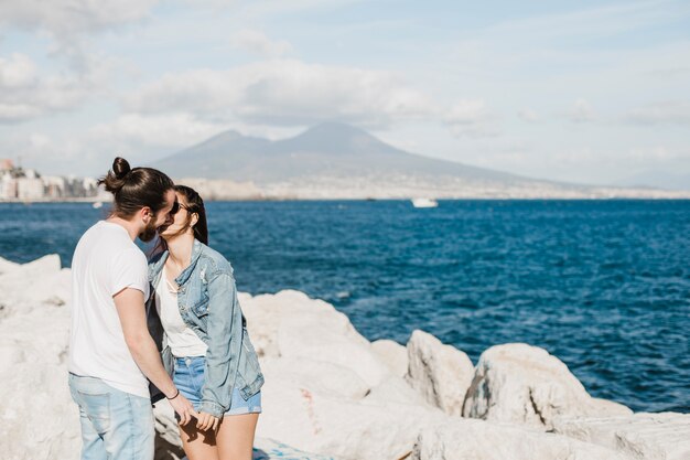 Concepto de pareja y verano en rocas por el mar