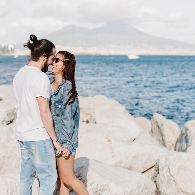 Foto gratuita concepto de pareja y verano en rocas por el mar