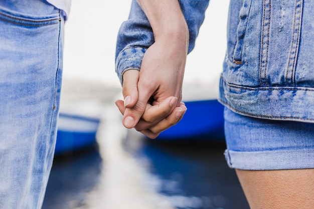 Concepto de pareja y verano con vista de cerca de pareja sujetando las manos