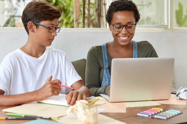 Concepto de personas y coworking. Jóvenes de raza mixta trabajan en proyecto escolar