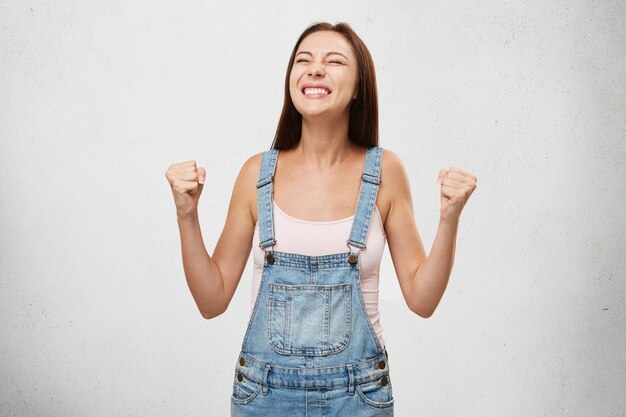 Concepto de personas, éxito, triunfo, victoria, emoción, metas, determinación y logros. Alegre mujer emocionada estudiante afortunada animando, celebrando el éxito, gritando sí con los puños cerrados