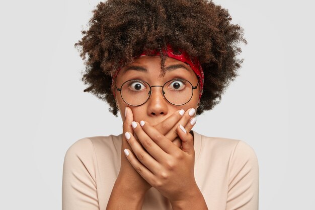 Concepto de personas y sorpresa. Estupefacta joven de piel oscura tiene los ojos abiertos