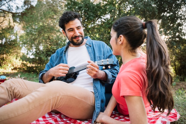 Concepto de picnic con pareja tocando la guitarra