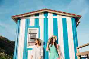 Foto gratuita concepto de playa y verano con mujeres enfrente de casa en playa