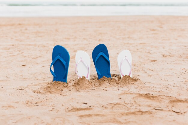 Concepto de playa con zapatillas en la arena