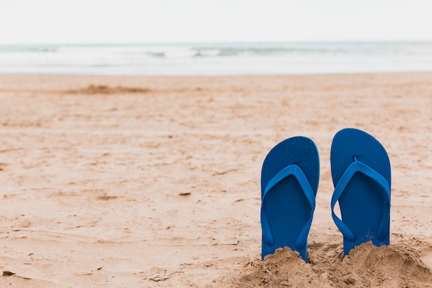 Concepto de playa con zapatillas en la arena