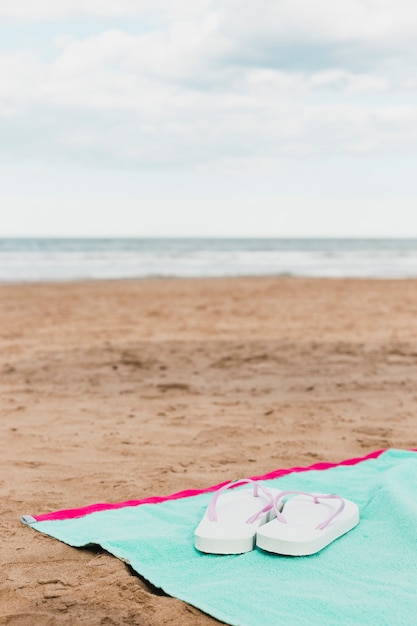 Concepto de playa con zapatillas en toalla