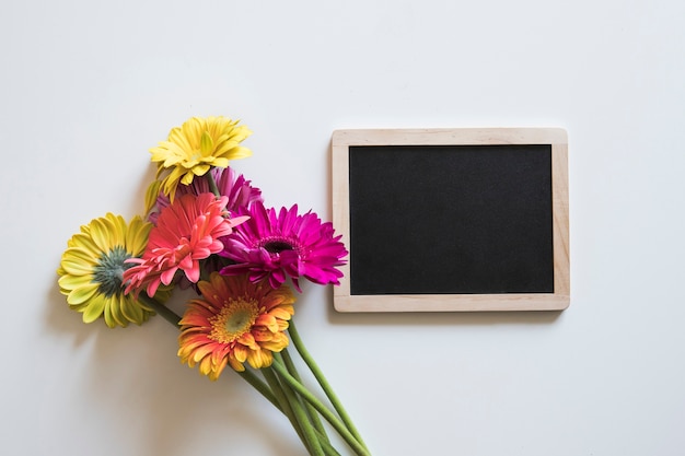 Foto gratuita concepto de primavera con flores al lado de pizarra