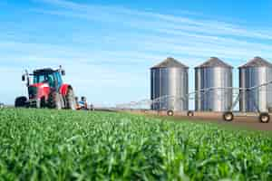 Foto gratuita concepto de producción agrícola y alimentaria con silos de máquinas tractoras y sistema de riego