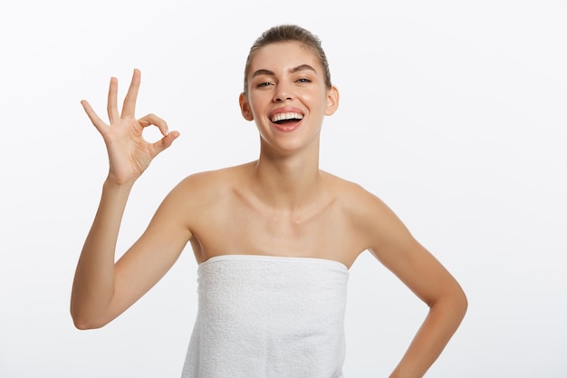 Concepto de publicidad Retrato de modelo de moda elegante después de la ducha con el símbolo ok aislado sobre fondo blanco.