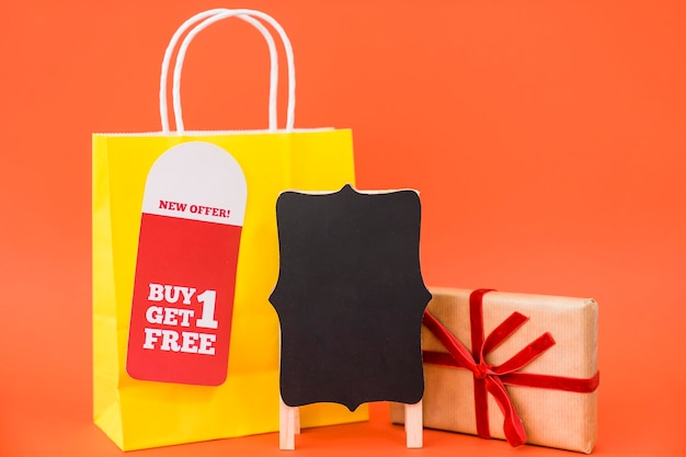 Concepto de rebajas de black friday con bolsa y caja de regalos detrás de tabla