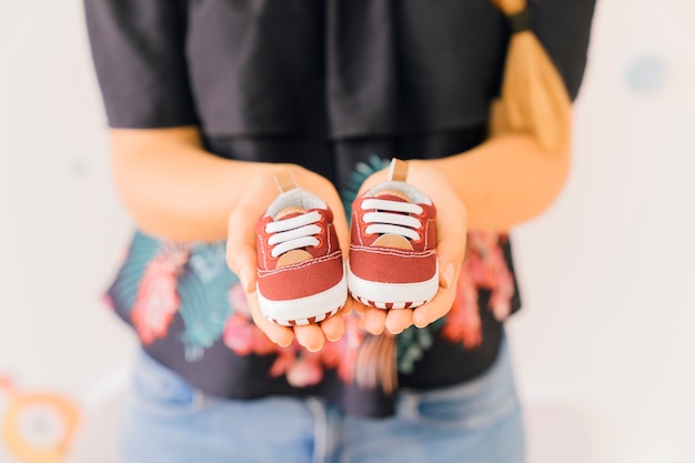 Concepto de recién nacido con mujer mostrando zapatos