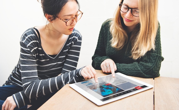 Concepto de redes de noticias de la tableta digital de la amistad de las mujeres