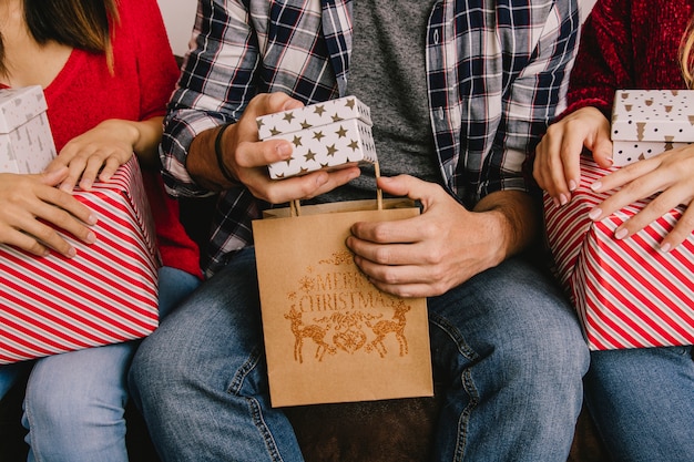 Concepto de regalar en navidad con amigos sujetando bolsa y regalos