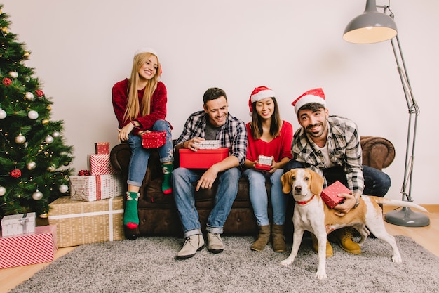 Concepto de regalos de navidad con amigos en sofá y perro