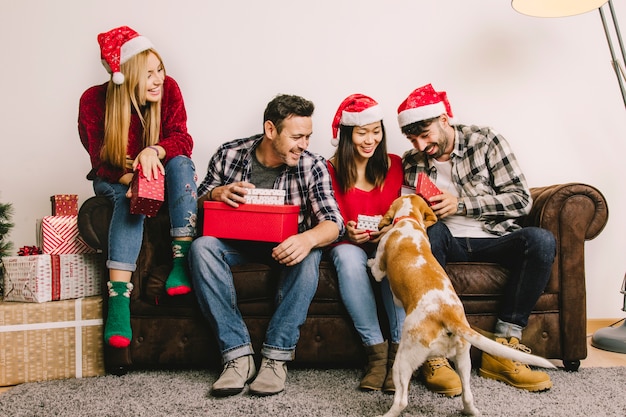 Foto gratuita concepto de regalos de navidad con amigos en sofá y perro