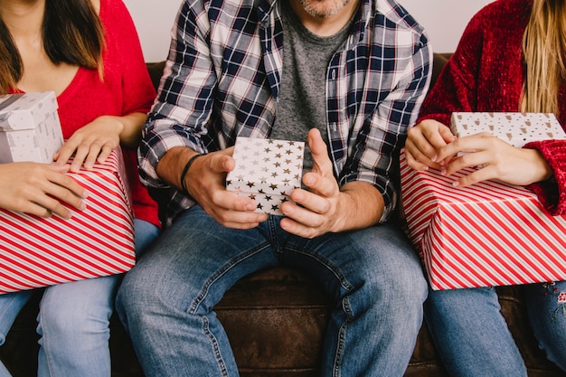 Concepto de regalos de navidad con tres amigos sujetando regalos