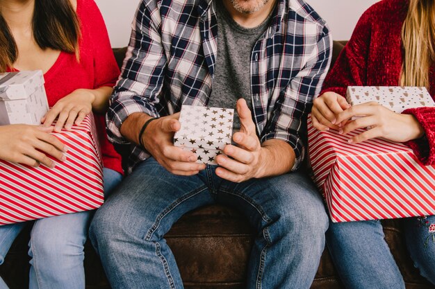 Concepto de regalos de navidad con tres amigos sujetando regalos